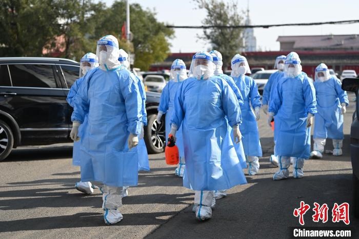圖為醫(yī)務(wù)人員在封閉小區(qū)做防控工作?！⑽娜A 攝