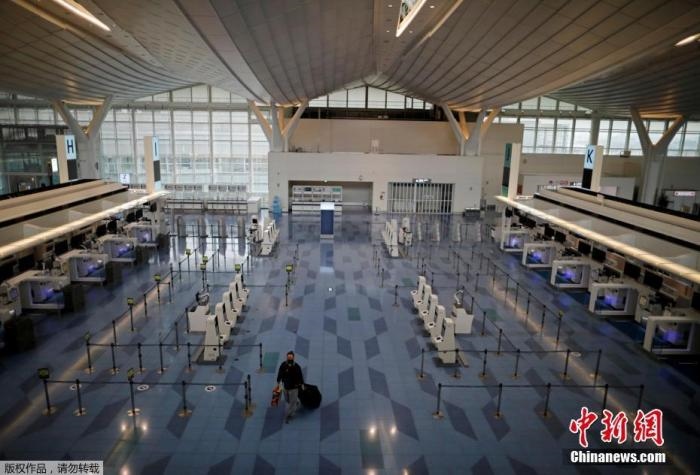 資料圖：日本東京，東京國(guó)際機(jī)場(chǎng)，一名乘客在國(guó)際航班航站樓的登機(jī)區(qū)。