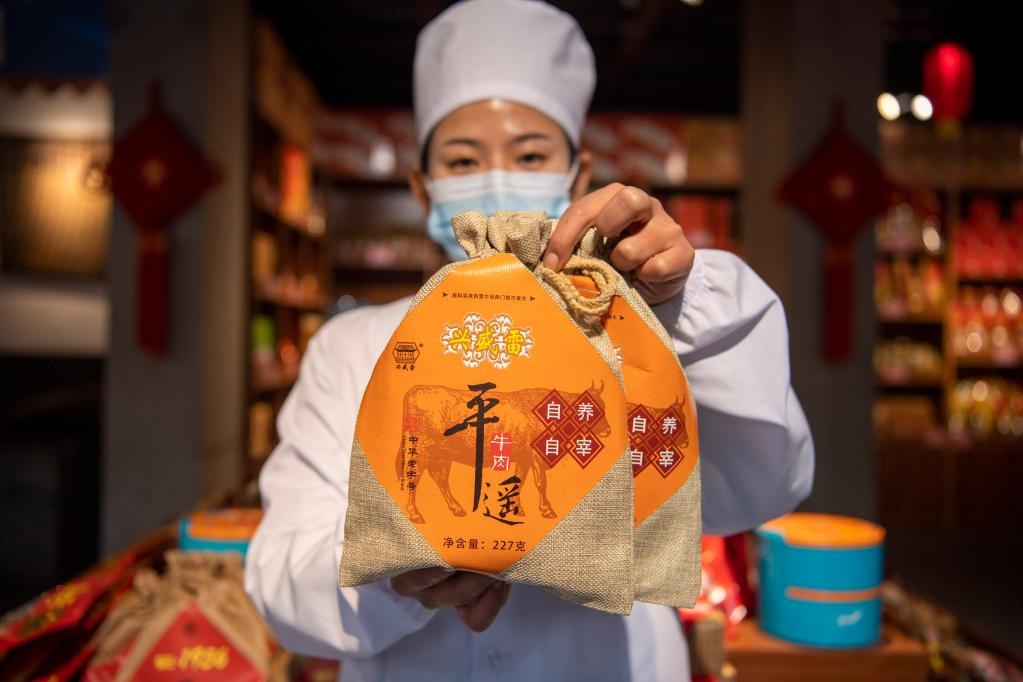 1月27日，在平遙古城南大街的一家平遙牛肉店內，工作人員展示一款牛肉產(chǎn)品。新華社記者 楊晨光 攝