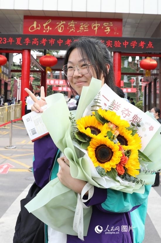 6月7日高考首日，山東67萬考生走進(jìn)考場，拼搏逐夢。在山東省實(shí)驗(yàn)中學(xué)考點(diǎn)，考生進(jìn)考場前手捧向日葵花拍照留念，寓意“一舉奪魁”。人民網(wǎng)記者 劉祺攝