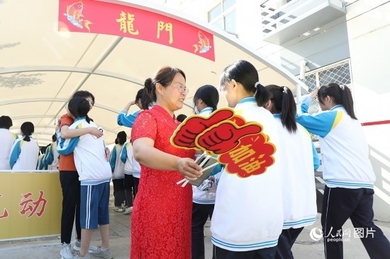 6月7日一早，雄安新區(qū)安新中學(xué)老師在給同學(xué)們加油鼓勁兒。人民網(wǎng) 李兆民攝
