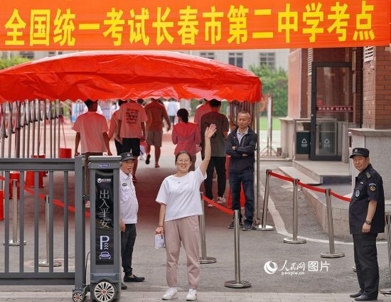 6月7日，在長春市第二中學(xué)考點(diǎn)，一名考生信心滿滿進(jìn)入考場，并與家長揮手致意。人民網(wǎng)記者 李洋攝