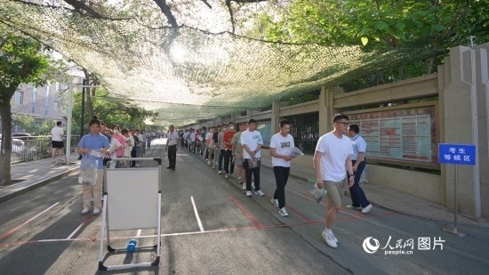 6月7日，烏魯木齊市第七十中學(xué)門口，考生們有序進(jìn)入考場。人民網(wǎng) 李欣洋攝