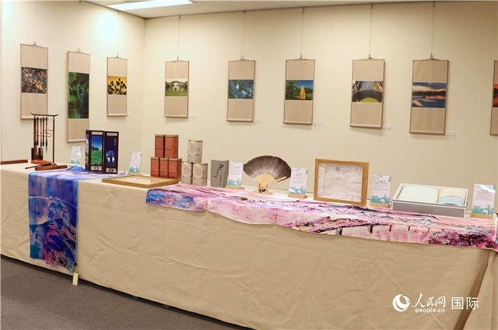 現(xiàn)場(chǎng)展出的馮學(xué)敏攝影作品與湖州市特色工藝品。（人民網(wǎng) 許可攝）