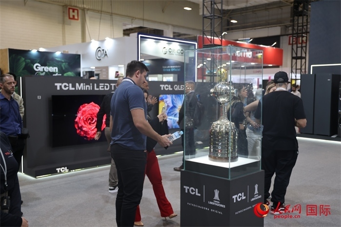 參觀者在TCL展臺(tái)前觀看南美解放者杯獎(jiǎng)杯，據(jù)介紹，TCL是南美解放者杯（2023—2026賽季）全球官方合作伙伴。（人民網(wǎng)記者 時(shí)元皓攝）