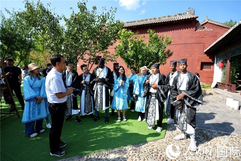 圖為選手們聽導游講解。人民網(wǎng) 盧鵬宇攝