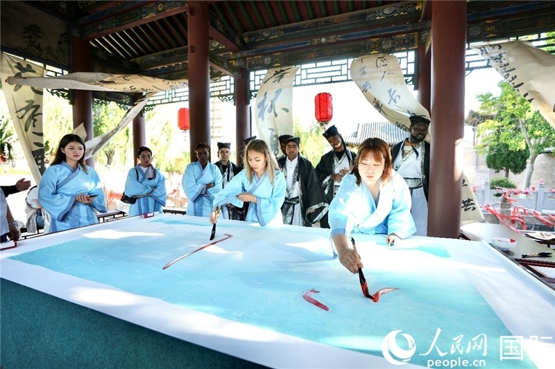 選手們提筆書寫“家園”二字。人民網(wǎng) 盧鵬宇攝