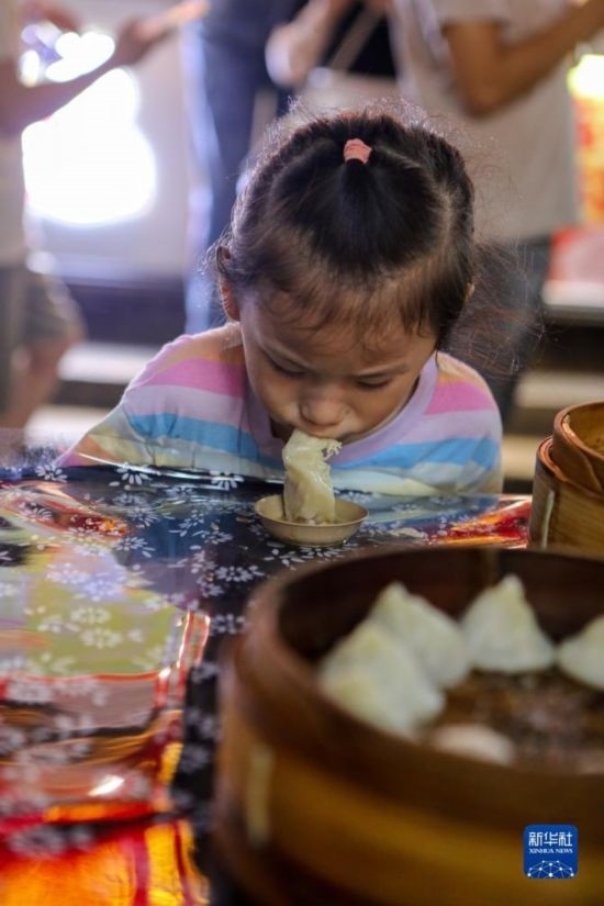 9月27日，小朋友在南翔小籠長(zhǎng)街宴上品嘗南翔小籠。