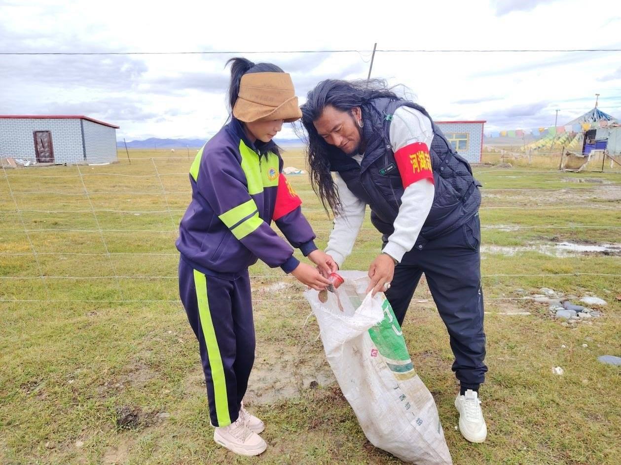 玉樹州稱多縣珍秦鎮(zhèn)河湖志愿者才培和他女兒更求拉毛在清掃垃圾。受訪者供圖