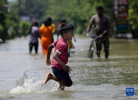 11月24日，一名男孩在斯里蘭卡加姆珀哈涉水出行。新華社發(fā)（阿吉特·佩雷拉攝）