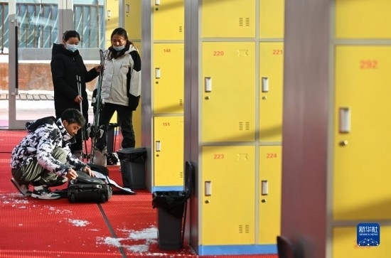 12月21日，游客在滑雪服務(wù)大廳整理滑雪裝備。