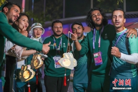 資料圖：9月29日，中國傳統(tǒng)節(jié)日中秋節(jié)，杭州亞運(yùn)會(huì)運(yùn)動(dòng)員村舉辦中秋主題活動(dòng)，中外運(yùn)動(dòng)員們歡聚一堂。圖為沙特阿拉伯運(yùn)動(dòng)員手持燈籠拍攝照片。<a target='_blank' href='/'><p align=