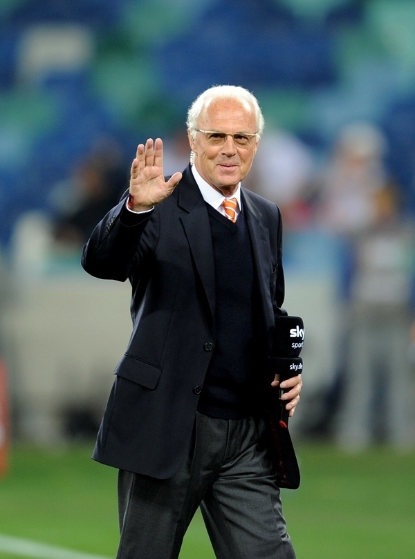 這是2010年7月7日，在南非德班舉行的2010年足球世界杯德國(guó)隊(duì)對(duì)陣西班牙隊(duì)的半決賽前，貝肯鮑爾接受電視臺(tái)采訪時(shí)和友人打招呼。新華社記者 王毓國(guó) 攝