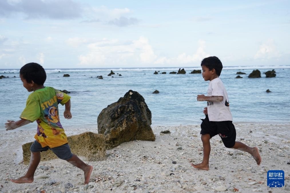 1月20日，兒童在瑙魯海邊嬉戲。新華社記者 王申 攝