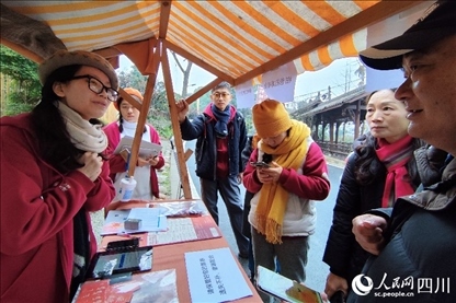 1月6日，“2024成都蒲江柑甜采摘節(jié)”上，記者見到了小萌（左一）和許多年輕人忙著做訪客接待、現(xiàn)場布置、票務(wù)核對、采摘服務(wù)等工作。人民網(wǎng)記者朱虹攝