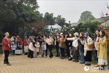 葉科（左一）給前來參與活動的“柑爸柑媽”介紹生態(tài)種植果。人民網(wǎng)記者朱虹攝