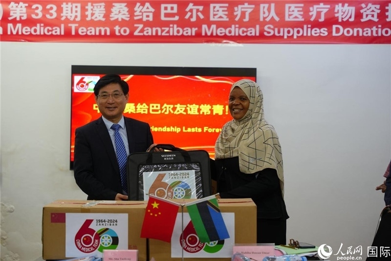 江蘇省蘇北人民醫(yī)院黨委書記束余聲捐贈物資與桑衛(wèi)生部首席秘書哈比巴。中國援桑醫(yī)療隊供圖