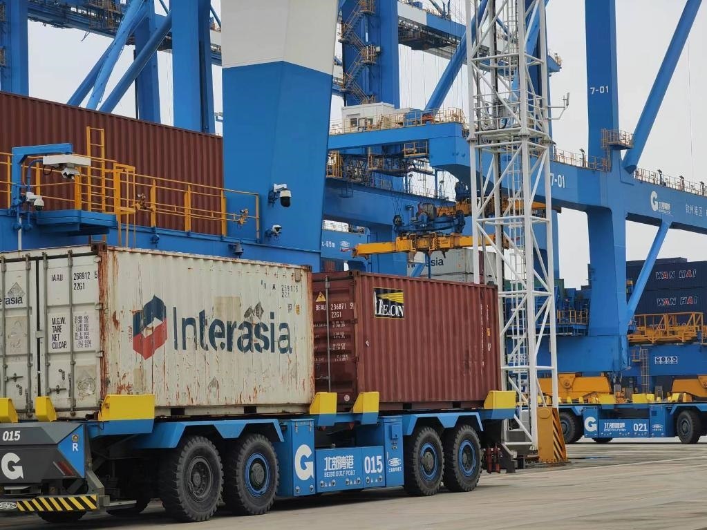 在欽州自動(dòng)化集裝箱碼頭，智能導(dǎo)引運(yùn)輸車在運(yùn)送集裝箱。新華社記者趙歡 攝