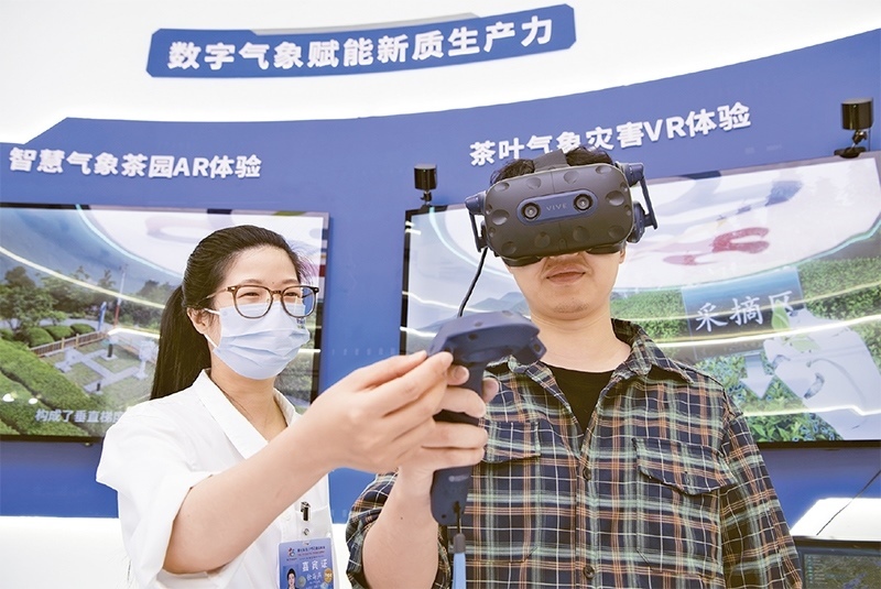 2024年5月23日，第七屆數(shù)字中國建設(shè)峰會現(xiàn)場體驗(yàn)區(qū)在福州海峽國際會展中心向?qū)I(yè)觀眾開放。本次現(xiàn)場體驗(yàn)區(qū)圍繞本屆峰會主題“釋放數(shù)據(jù)要素價值，發(fā)展新質(zhì)生產(chǎn)力”，設(shè)置“數(shù)字惠民”、“數(shù)字能力”、“數(shù)字基礎(chǔ)”、“數(shù)字生態(tài)”、“數(shù)字賦能”五大板塊。圖為一名觀眾（右）在數(shù)字氣象賦能新質(zhì)生產(chǎn)力展臺上進(jìn)行體驗(yàn)。 新華社記者 魏培全/攝