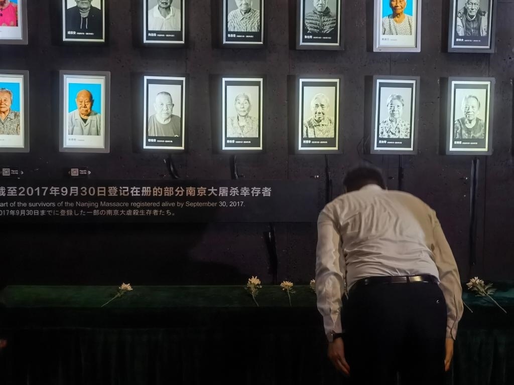 7月18日，人們向離世的南京大屠殺幸存者獻(xiàn)花、鞠躬。新華社記者邱冰清 攝