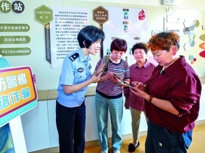 浙江湖州民警指導(dǎo)居民加入湖州“e企安”微信群，實(shí)時(shí)接收反詐信息。新華社發(fā)