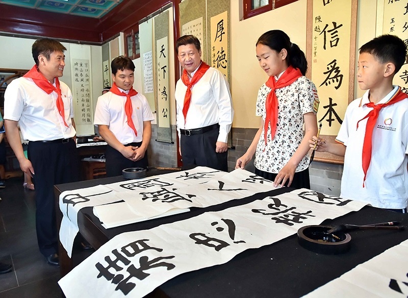2014年5月30日，習(xí)近平總書記來到北京市海淀區(qū)民族小學(xué)，參加慶?！傲弧眹H兒童節(jié)活動。這是總書記觀看學(xué)生書寫的毛筆字。
