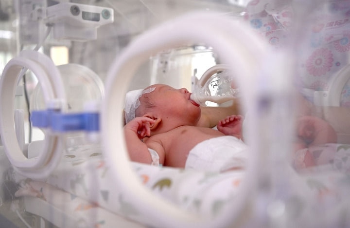 2024年6月1日，在西安國際醫(yī)學中心醫(yī)院新生兒科病房，護士為新生兒喂奶。 新華社記者 劉瀟 攝