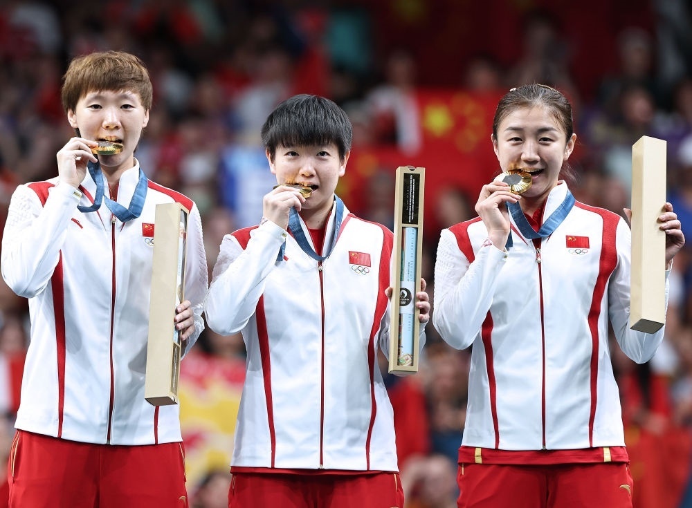 冠軍中國隊選手王曼昱、孫穎莎、陳夢（從左至右）在巴黎奧運會乒乓球女子團體頒獎儀式上（2024年8月10日攝）。新華社記者 王東震 攝