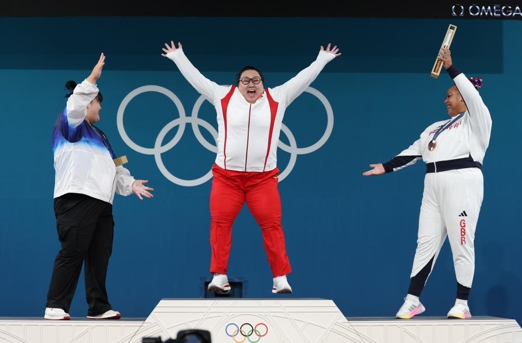 中國選手李雯雯（中）在巴黎奧運會舉重女子81公斤以上級頒獎儀式中登上領獎臺（2024年8月11日攝）。新華社記者 楊磊 攝