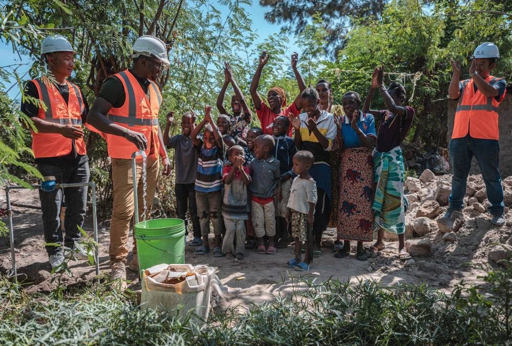 2023年6月13日，在坦桑尼亞姆萬扎省米松圭，工作人員接通水管后贏得當地居民鼓掌歡呼。新華社記者 王冠森 攝