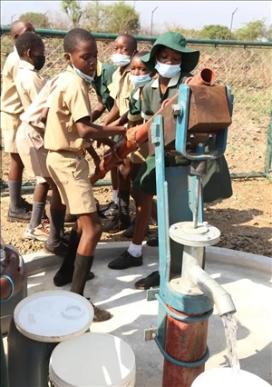 △2021年11月，在津巴布韋南馬塔貝萊蘭省省會關(guān)達(dá)的塞農(nóng)多小學(xué)，學(xué)生從中國援建水井里打水。