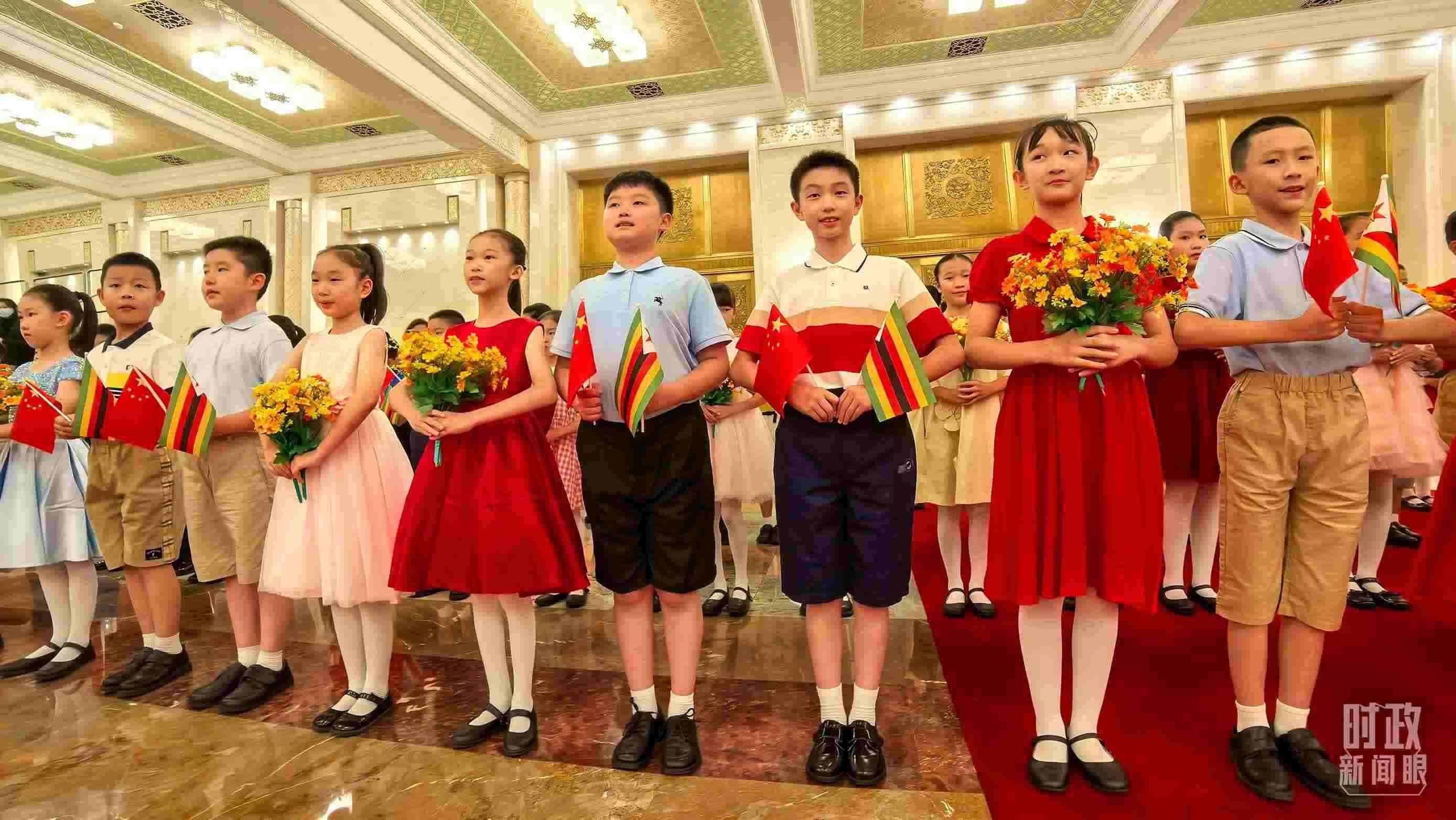 △現(xiàn)場歡迎津巴布韋總統(tǒng)訪華的青少年。（總臺(tái)央視記者鐘銳拍攝）