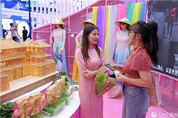 參觀者在東博會(huì)越南展區(qū)同工作人員咨詢交談。人民網(wǎng)記者 趙益普攝