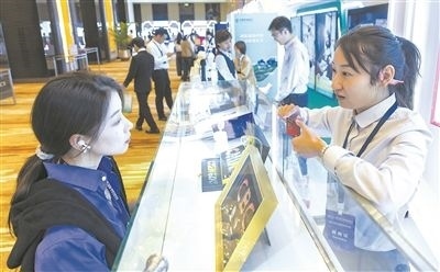 在北京麗澤商務(wù)區(qū)，工作人員（右一）介紹數(shù)字人民幣SIM卡硬錢包。新京報(bào)記者 陶冉攝