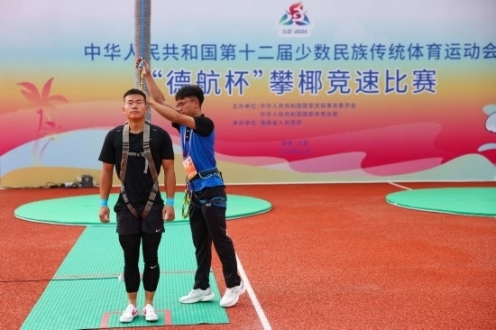 11月23日，工作人員為上海隊選手付樂樂（左）系安全繩。新華社記者 楊植森 攝