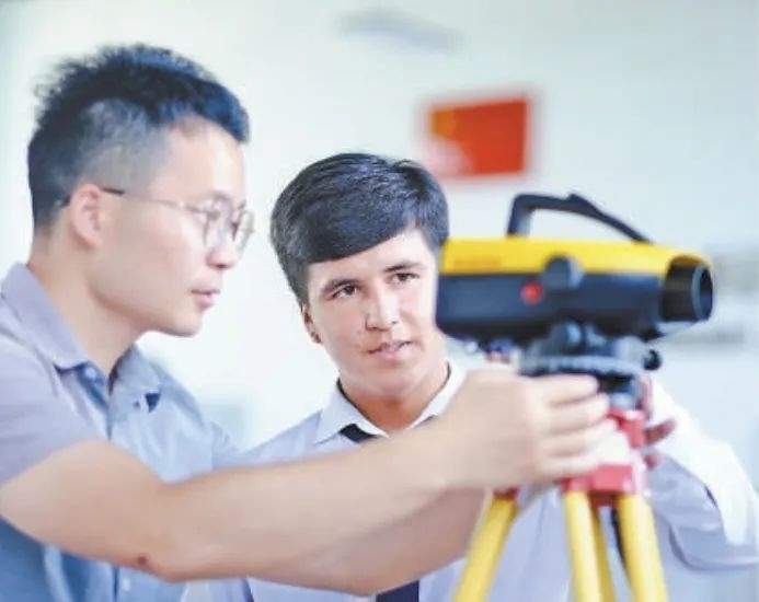 在塔吉克斯坦首都杜尚別的魯班工坊，來自天津城市建設(shè)管理職業(yè)技術(shù)學(xué)院的老師（左）為當(dāng)?shù)貙W(xué)生提供指導(dǎo)。新華社記者 鄭開君 攝