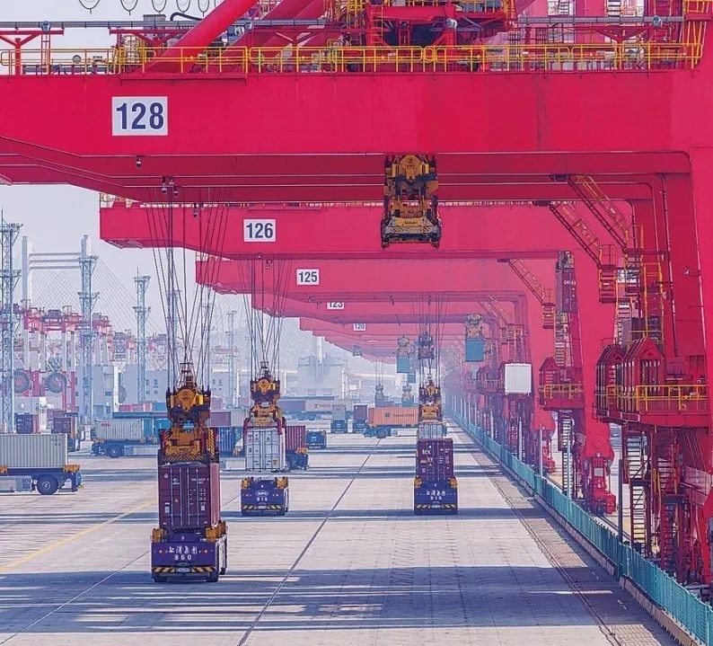 共建“一帶一路”國(guó)家在工作制度對(duì)接、技術(shù)標(biāo)準(zhǔn)協(xié)調(diào)、檢驗(yàn)結(jié)果互認(rèn)等方面強(qiáng)化合作、統(tǒng)一標(biāo)準(zhǔn)，貿(mào)易自由化便利化水平不斷提升。上海洋山港海關(guān)對(duì)接共建國(guó)家進(jìn)出口貨物相關(guān)標(biāo)準(zhǔn)，推動(dòng)通關(guān)一體化方式申報(bào)，提升通關(guān)效率。圖為無人駕駛的全自動(dòng)導(dǎo)引車在洋山港穿梭往來，搬運(yùn)集裝箱。王初 攝