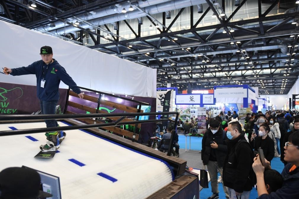 2023年2月11日，參觀者在展會上了解一款模擬滑雪設(shè)備。當(dāng)日，2023亞洲運動用品與時尚展在國家會議中心拉開帷幕。新華社記者 張晨霖 攝