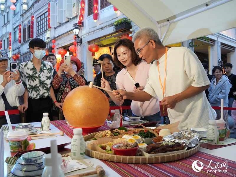 嘉賓品嘗海南傳統(tǒng)美食“煎堆”。人民網(wǎng)記者 張力洋攝