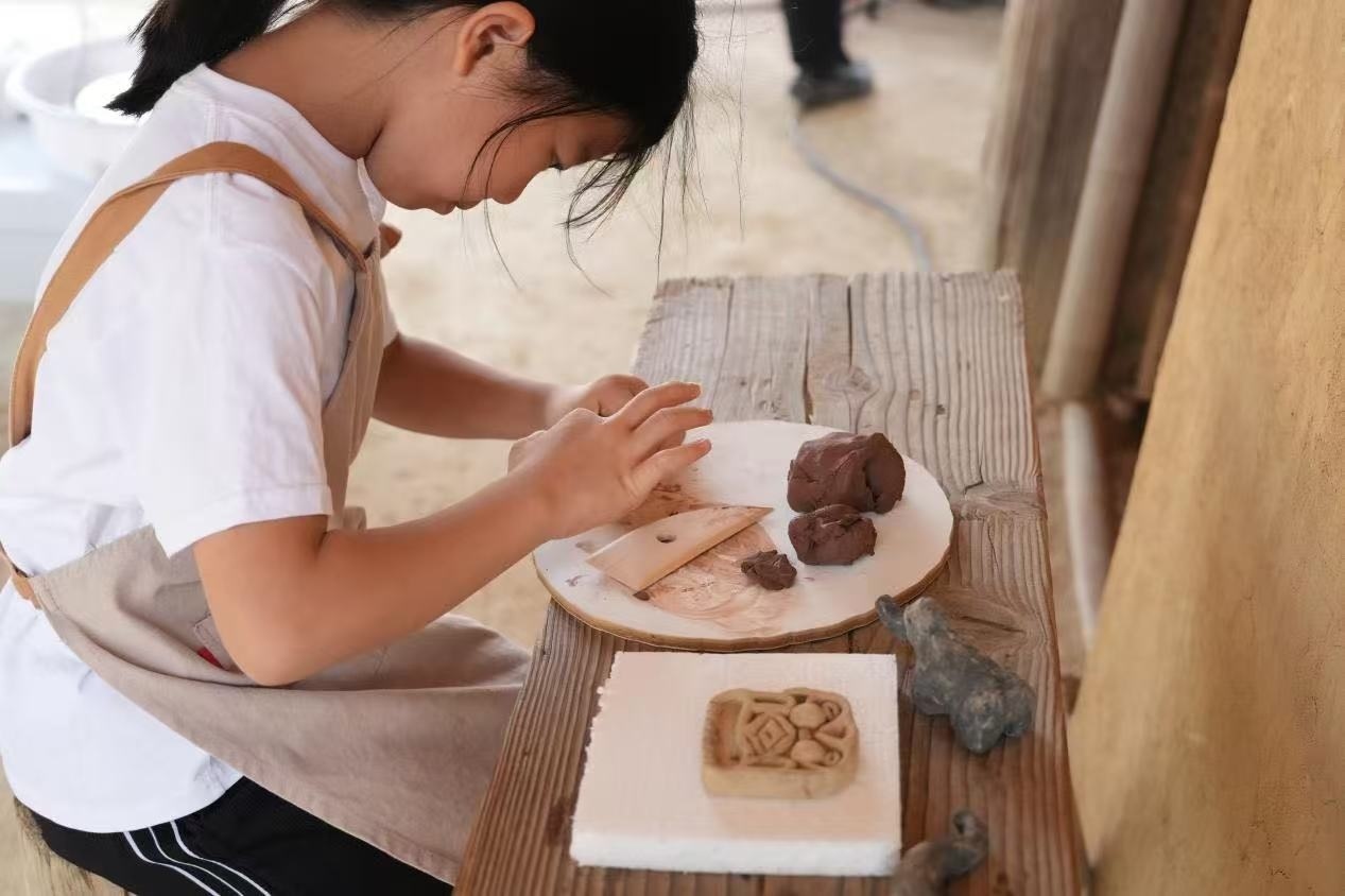 游客制作良渚特色陶藝品。良渚博物院供圖